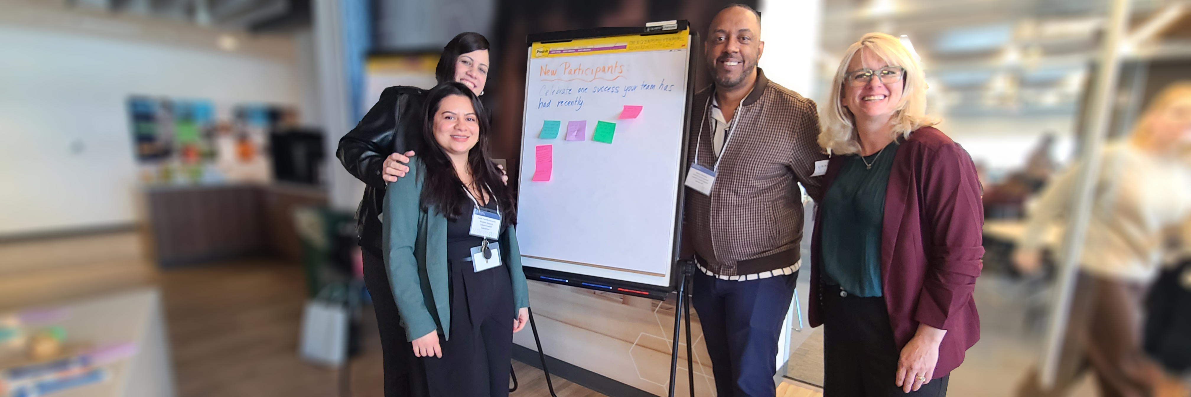 New Directors Orientation 2026-04-10 Three women and one man standing beside a flip chart where participants have written program successes 