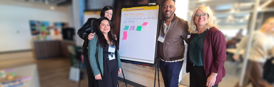 New Directors Orientation 2026-04-10 Three women and one man standing beside a flip chart where participants have written program successes 