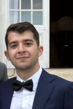 Alec Powers headshot smiling with bowtie